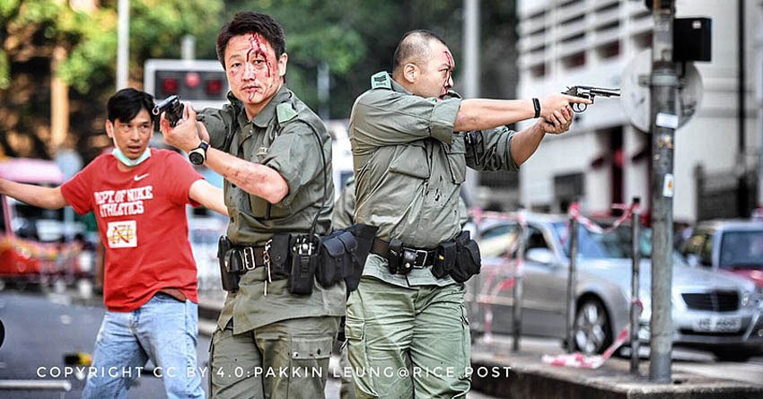 Zwei hongkonger Polizisten, die von ihren Pistolen zur Abschreckung Gebrauch machen und Warnschüsse abgeben, Foto: Pakkin Leung@Rice Post, Wikipedia, CC-BY 4.0